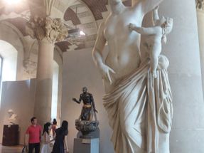 I found this interesting sculpture in the Louvre Museum. The black sculpture in the background is a Roman copy of an ancient Greek sculpture called The Old Fisherman.