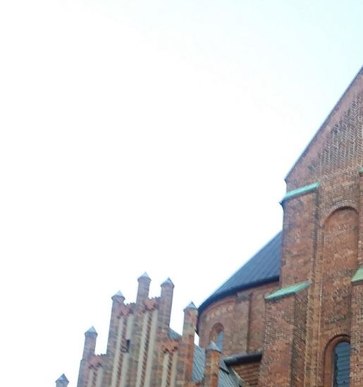 We are about to pass the north side of Roskilde Cathedral at Oluf Mortensens' porch built around 1450. The gable was constructed in the Late Medieval Gothic architectural style of North Germany.