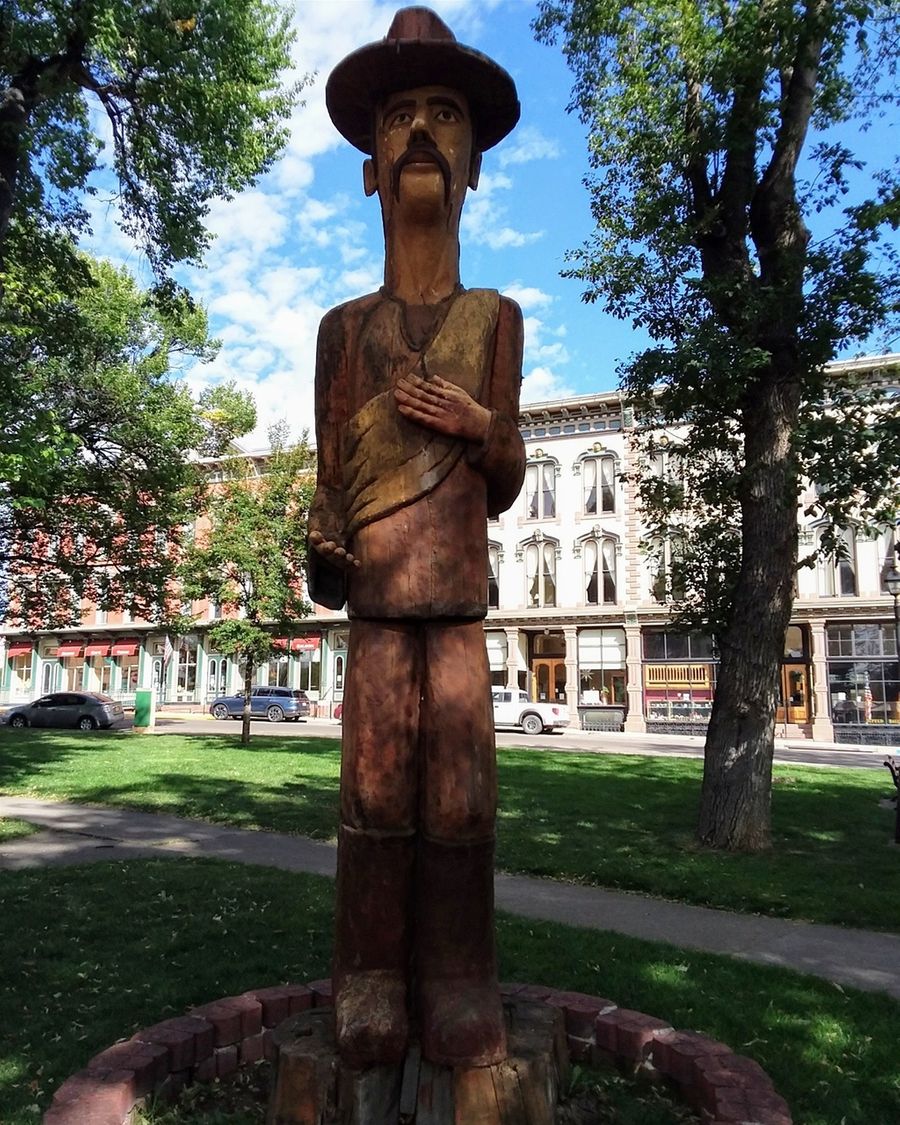 Las Vegas NM is about half way between Albuquerque NM and the Colorado/New Mexico state line on interstate 25. The Plaza Hotel where we stayed can be seen behind this wood statue on the left side. The statue is dedicated to the campesinos or farmers.