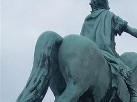 A second view from the center of Amalienborg Palace courtyard with the equistrian statue with King Fredrik V in the forground and Fredricks'Church in the background.